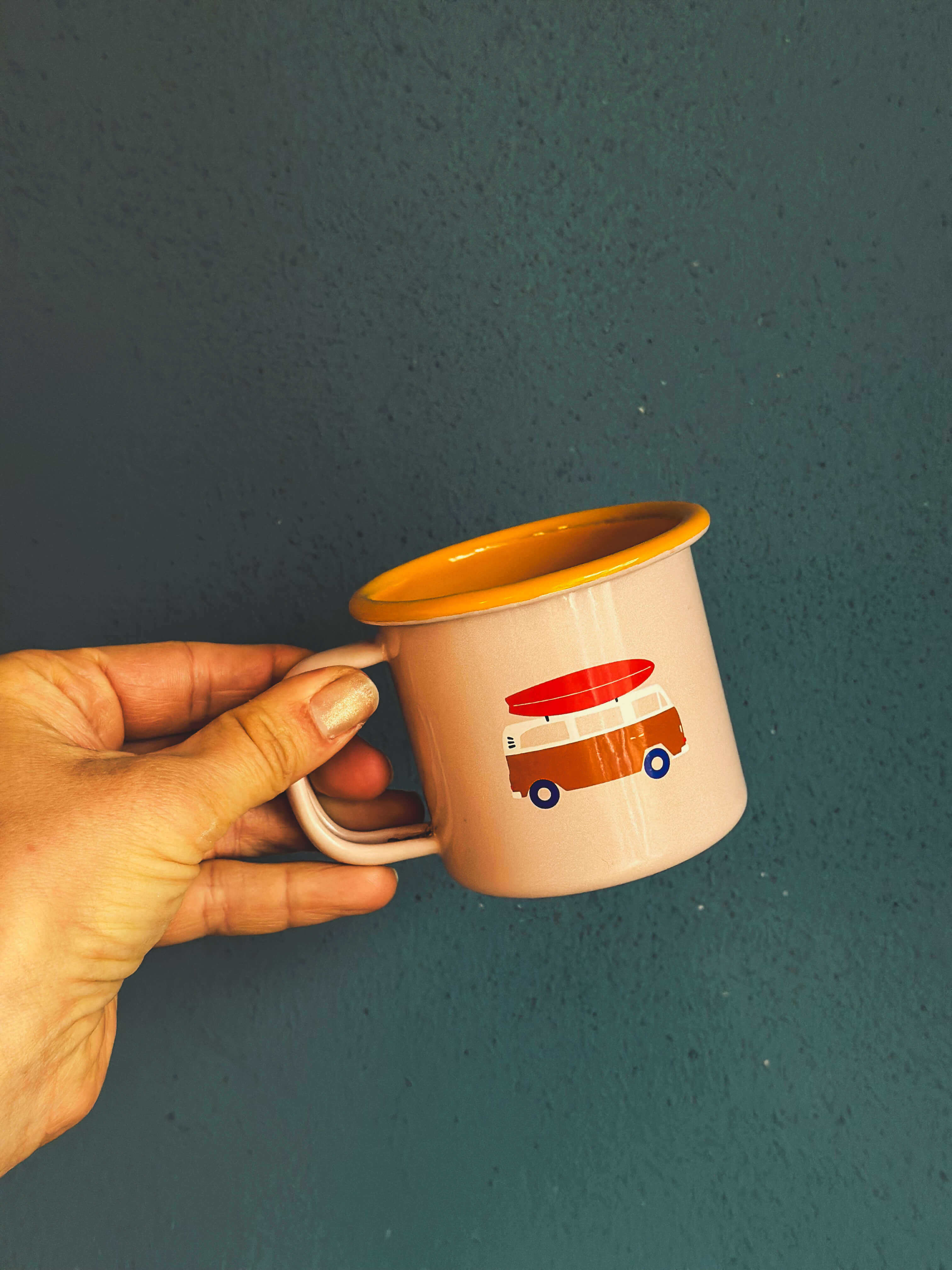 Roadtyping Emaille Tasse für Kinder in rosa mit Bulli von einer Hand gehalten