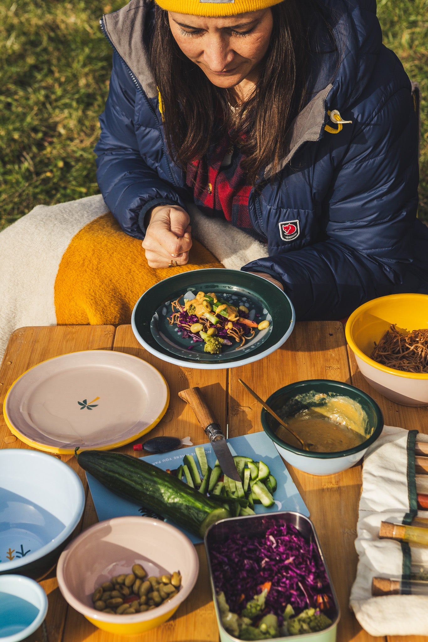 Frau beim Essen vor dem Camper mit buntem Camping Geschirr aus Emaille von Roadtyping