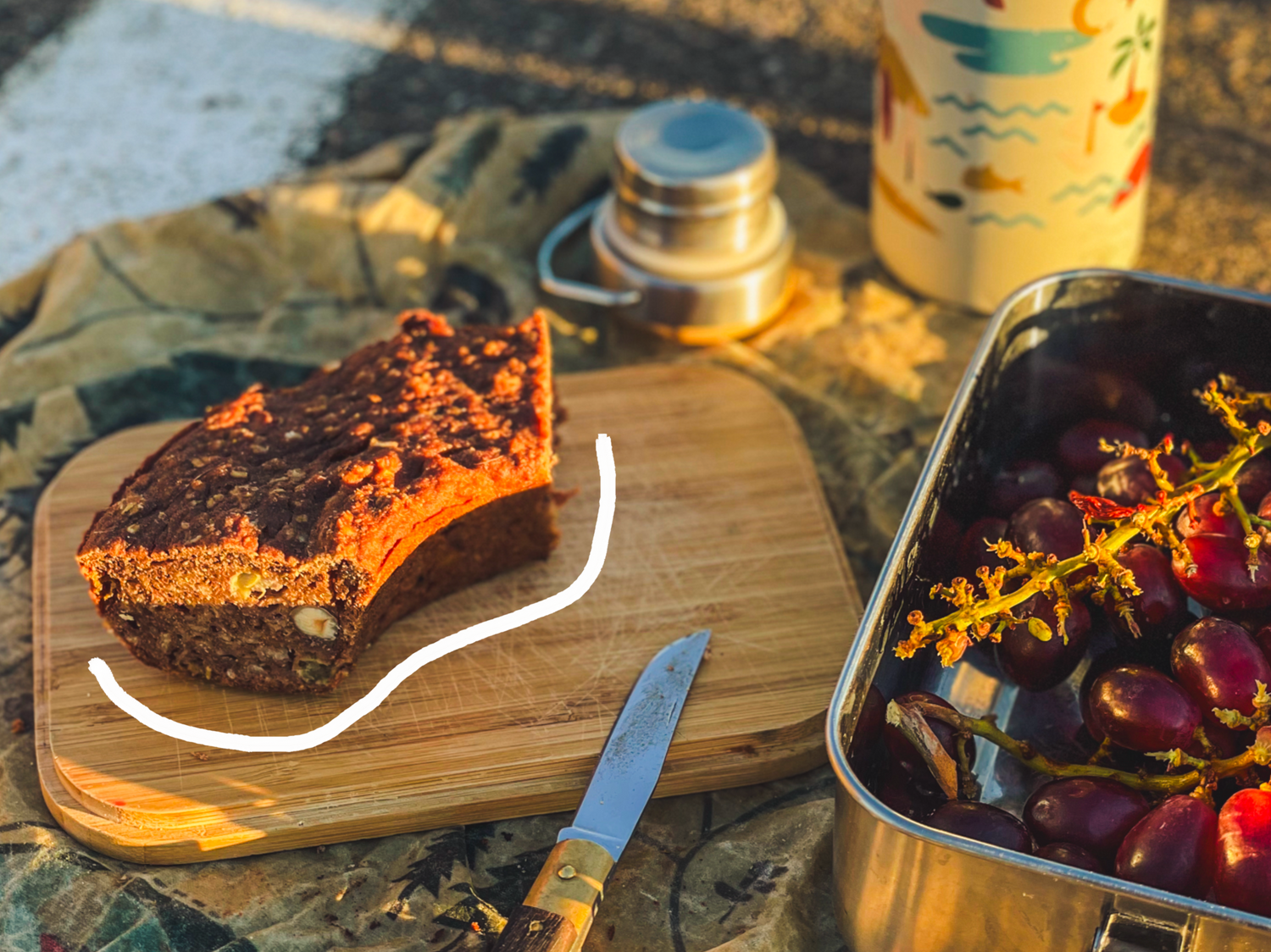 Bananenbrot aus dem Omnia auf Schneidebrett Deckel der Lunchbox von Roadtyping 