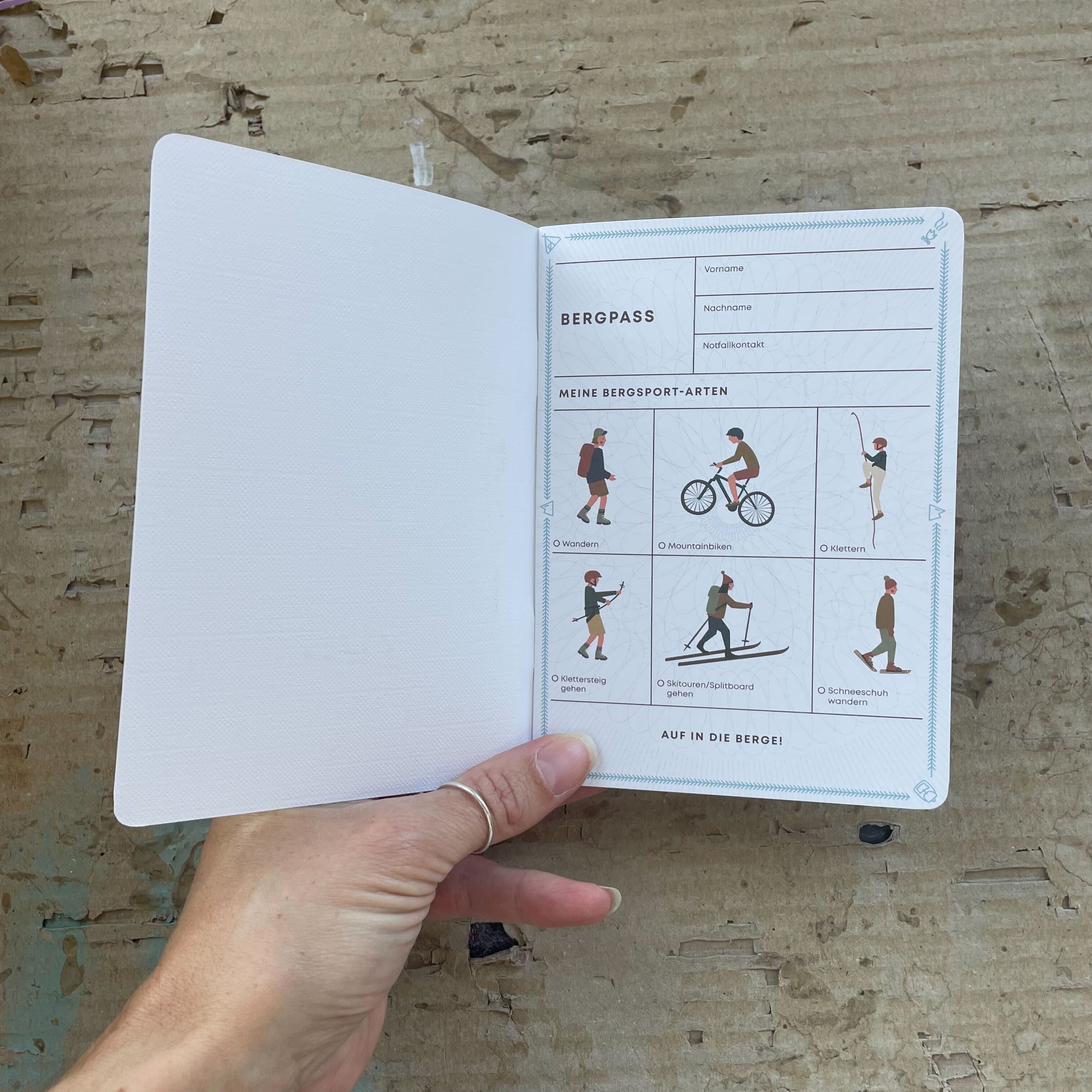Roadtyping Berg- und Gipfelpass, offen auf einer Seite, mit vorgefertigten Feldern und Zeilen zum Eintragen von Wanderungen, Erlebnissen und Stempeln. Er ist für Abenteurer, Wanderer, Kletterer und Mountainbiker gedacht, aber auch für jeden, der seine Bergmomente festhalten möchte.