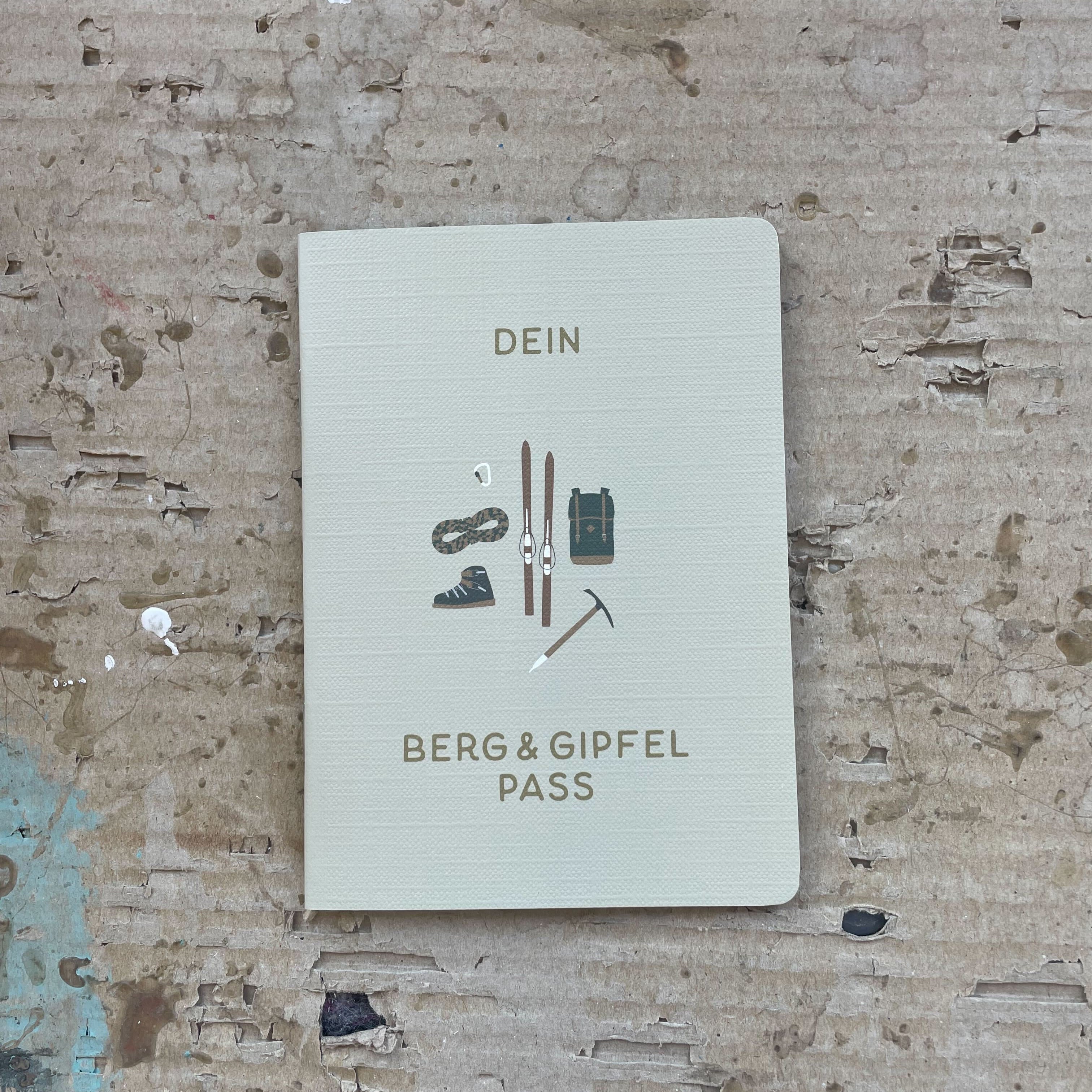 Roadtyping Berg- und Gipfelpass, offen auf einer Seite, mit vorgefertigten Feldern und Zeilen zum Eintragen von Wanderungen, Erlebnissen und Stempeln. Er ist für Abenteurer, Wanderer, Kletterer und Mountainbiker gedacht, aber auch für jeden, der seine Bergmomente festhalten möchte.
