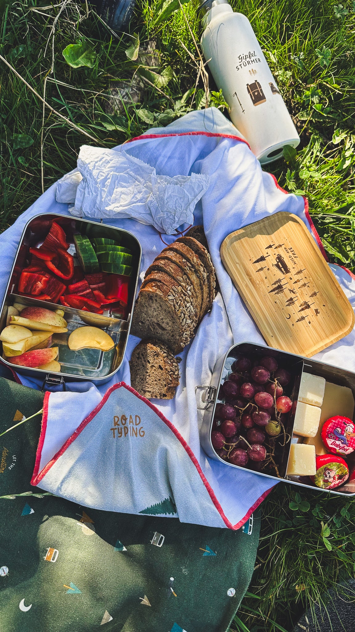 Gipfelbrotzeit mit Brotdose, Lunchbag und Gipfelstürmer Flasche von Roadtyping in einer Wiese