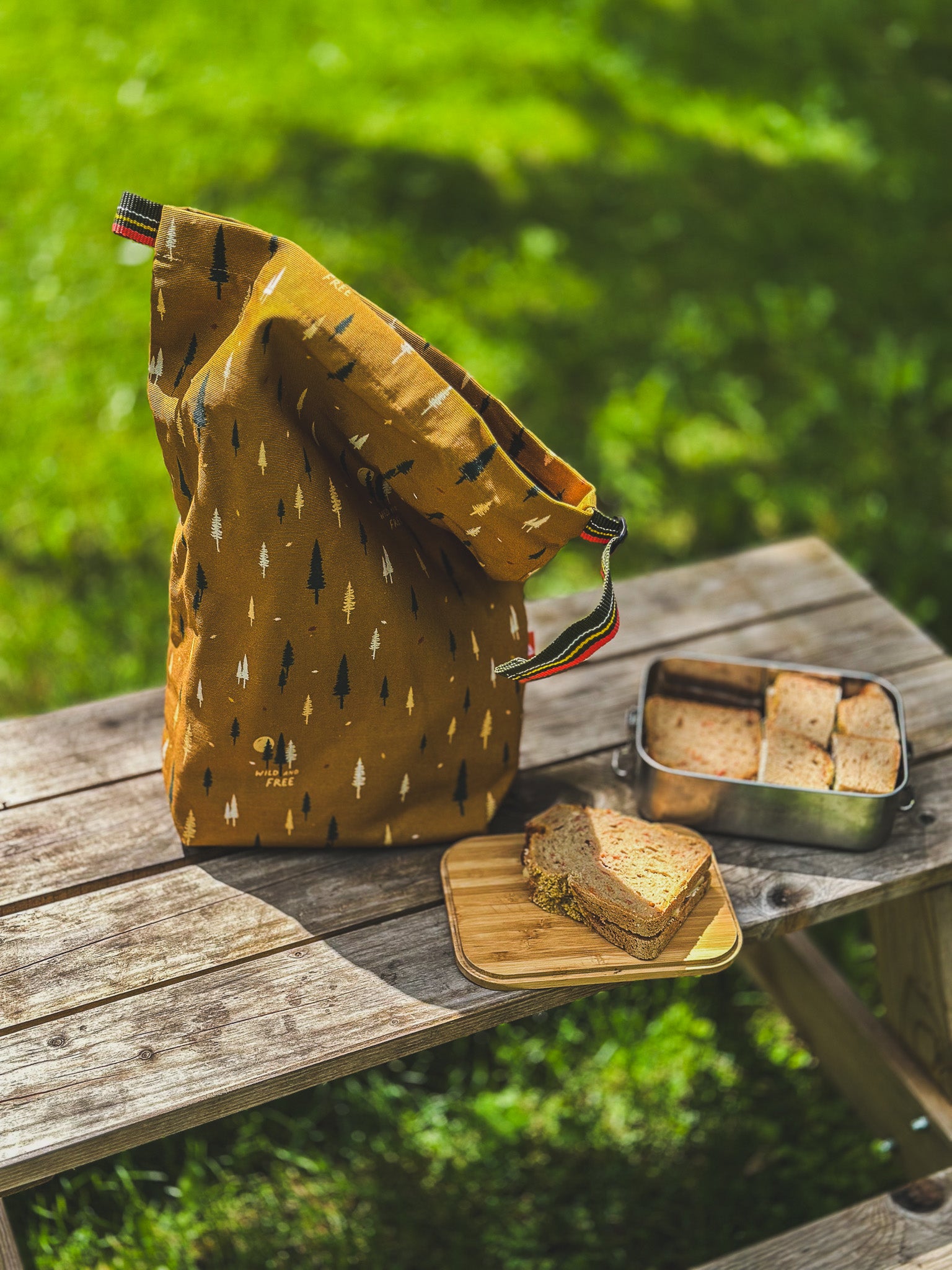 Braunen Lunchbag mit Bäumen von Roadtyping mit Brotdose auf Picknicktable