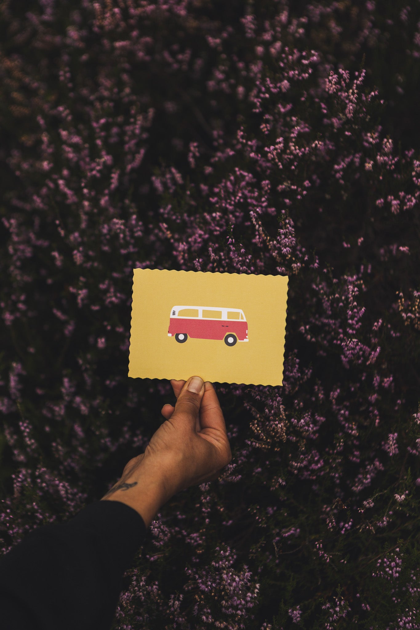 Illustration einer roten Retro-Camper_postkarte im minimalistischen Design auf gelbem Hintergund. Symbol für Roadtrip, Vanlife und Abenteuer. 