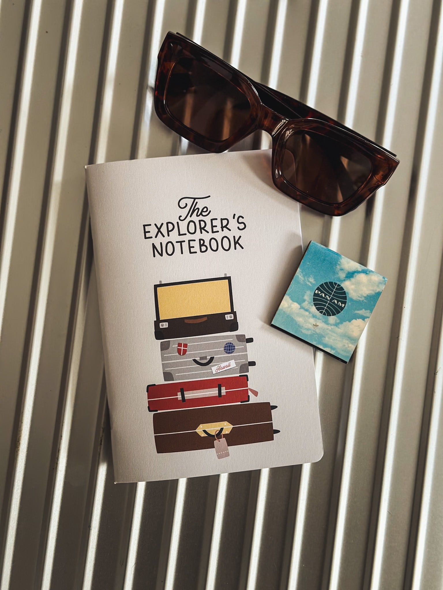 Reisetagebuch The Explorers Notebook Band 7 liegt auf einem Rimowa Koffern neben Streichhölzern von Panam